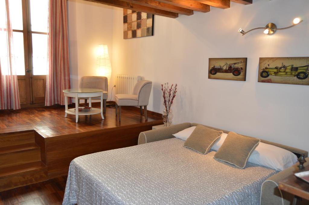 - une chambre avec un lit, une table et des chaises dans l'établissement Apartamentos Nuncio Viejo, à Tolède