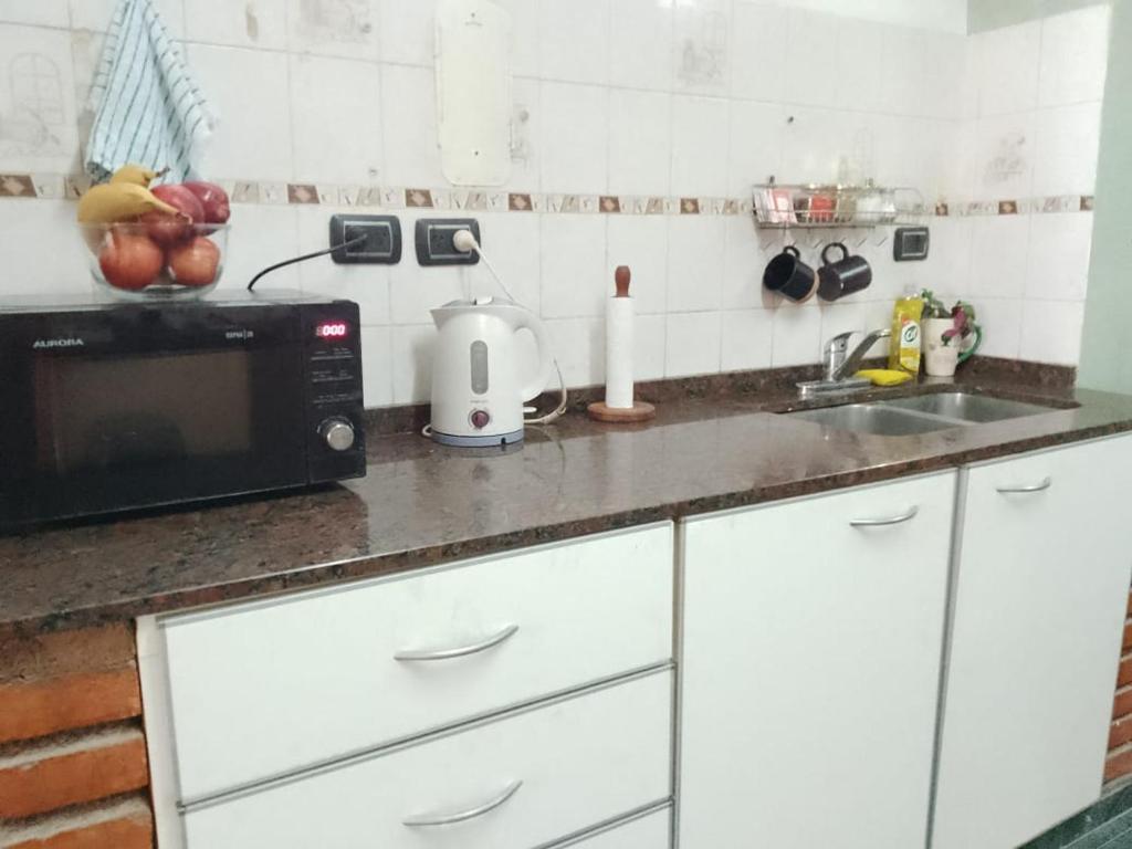 encimera de cocina con microondas y fregadero en Como en Casa en Comodoro Rivadavia
