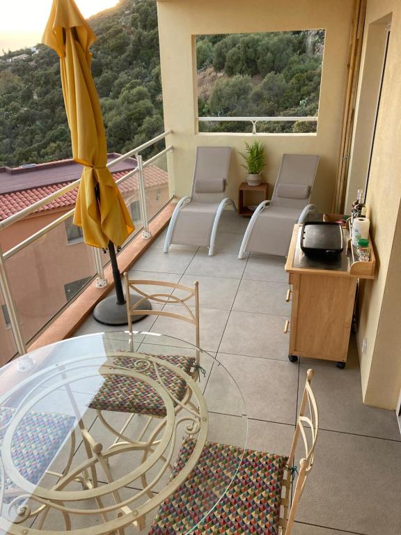 Cette chambre dispose d'un balcon avec une table et des chaises en verre. dans l'établissement ajaccio Sanguinaires, à Ajaccio