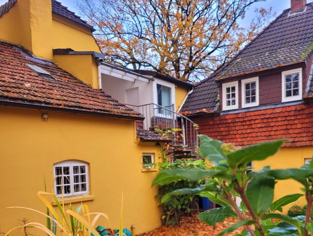 a yellow house with a balcony on the side of it at Apartment Atelierhaus Wencke in Worpswede