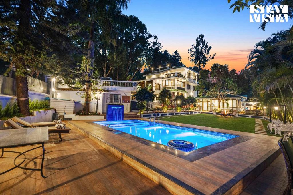 a backyard with a swimming pool and a house at StayVista's Grace & Light - Hill-view villa with Outdoor pool, Terrace & Games room in Panchgani