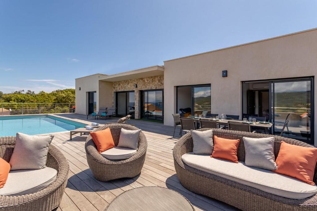 une terrasse avec des chaises en osier et une piscine dans l'établissement Villa Mamone Corse 10P seaview and private pool Favone beach 5min, à Conca