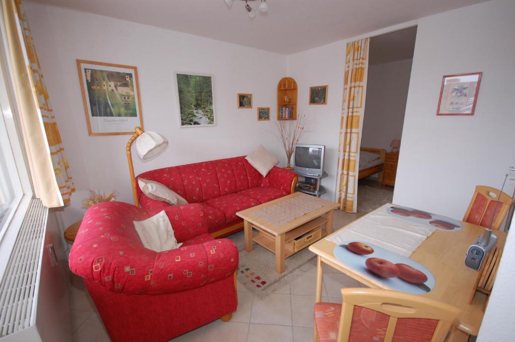 sala de estar con sofá rojo y mesa en Ferienwohnung Petunie, en Altenau
