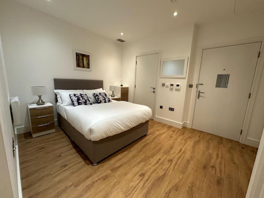 1 dormitorio con 1 cama y suelo de madera en Hanger Lane Luxury Apartment, en Perivale