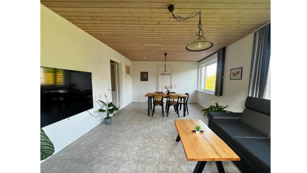 - un salon avec une table et un canapé dans l'établissement Cozy Rødbyhavn Villa - Lalandia/Puttgarden/Femern, à Rødby