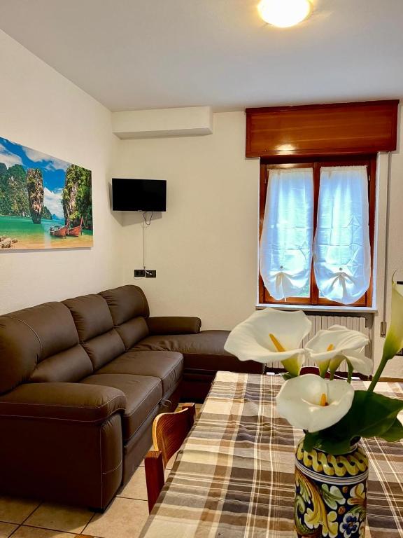 uma sala de estar com um sofá castanho e uma janela em Perla house em Abbadia Lariana
