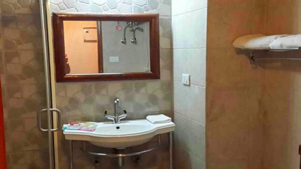 y baño con lavabo y espejo. en Wingait Inn - Hotel Near The Mall Road, en Shimla