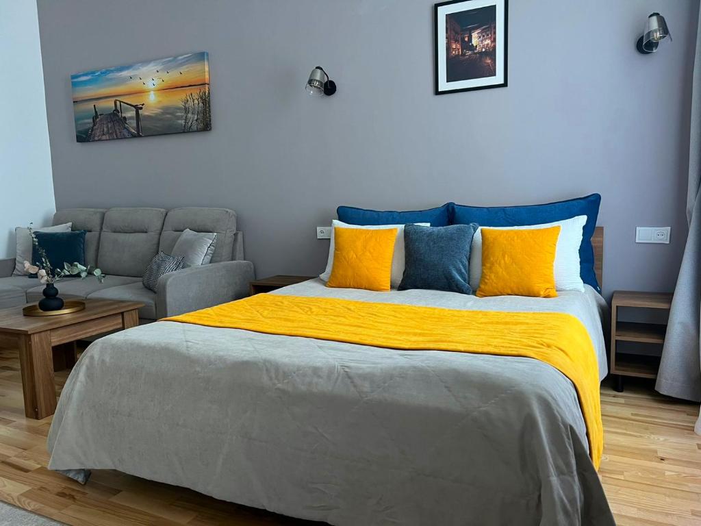 1 dormitorio con 1 cama con almohadas amarillas y azules en Fiesta Apartment on Franka 2BR-6P, en Leópolis