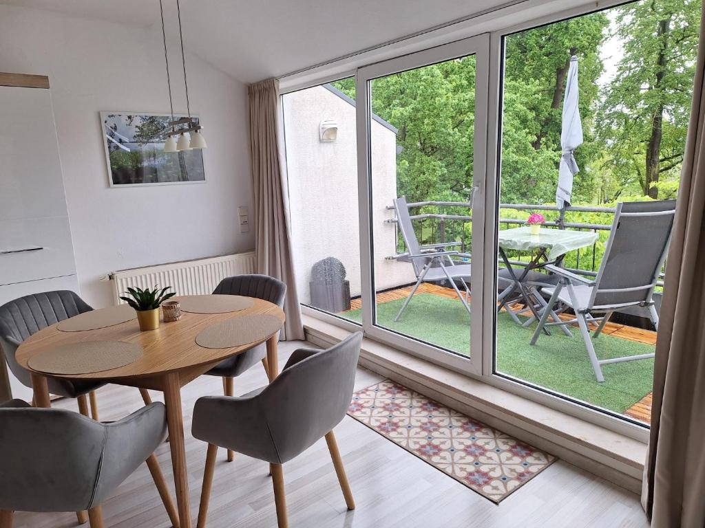 ein Wohnzimmer mit einem Tisch, Stühlen und einem Fenster in der Unterkunft Ferienwohnung " Haus am Meer " in Bad Zwischenahn