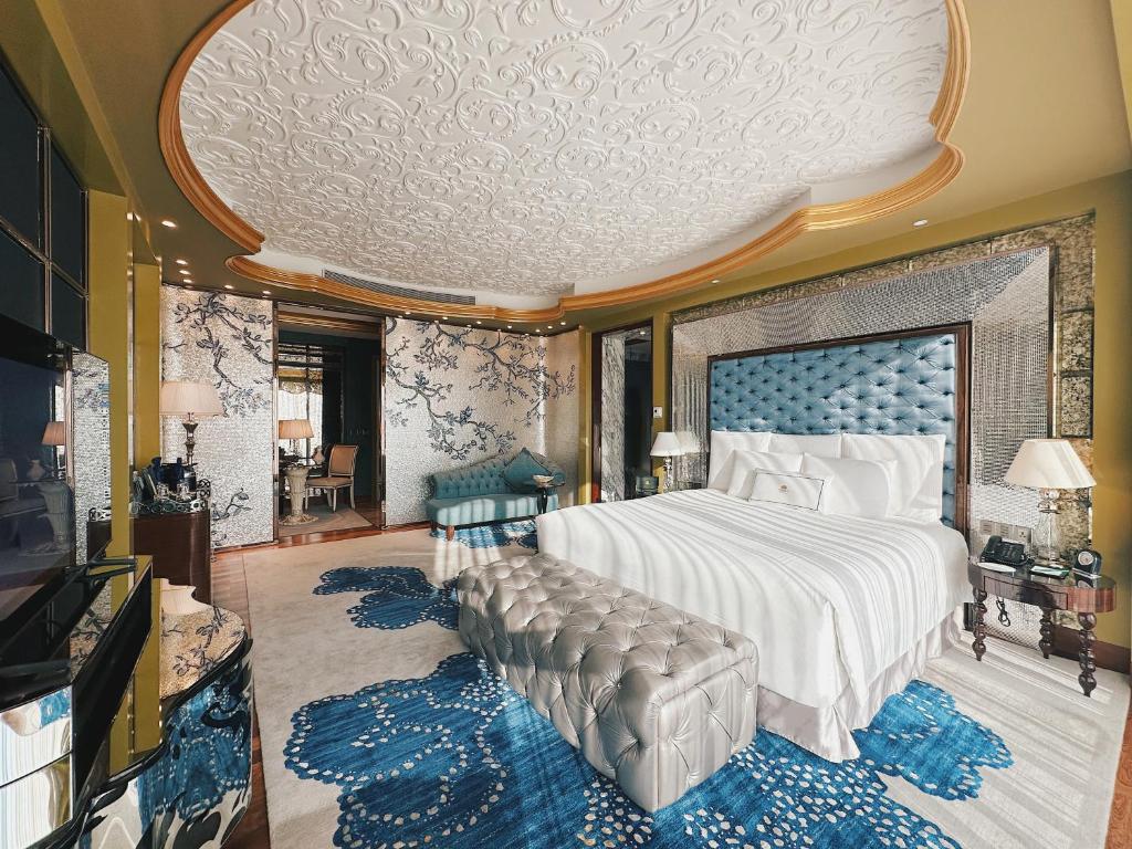 a bedroom with a large bed with a blue headboard at The Reverie Saigon in Ho Chi Minh City