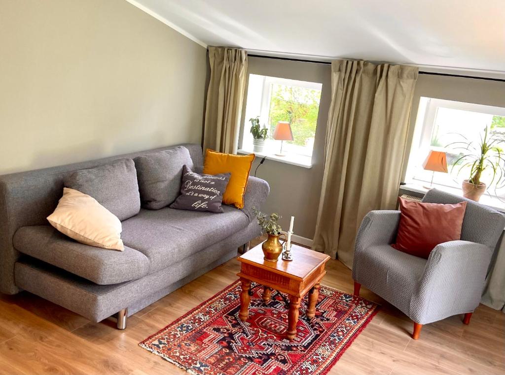 a living room with a couch and a chair at Ferienwohnung an der Schlei oben in Fleckeby