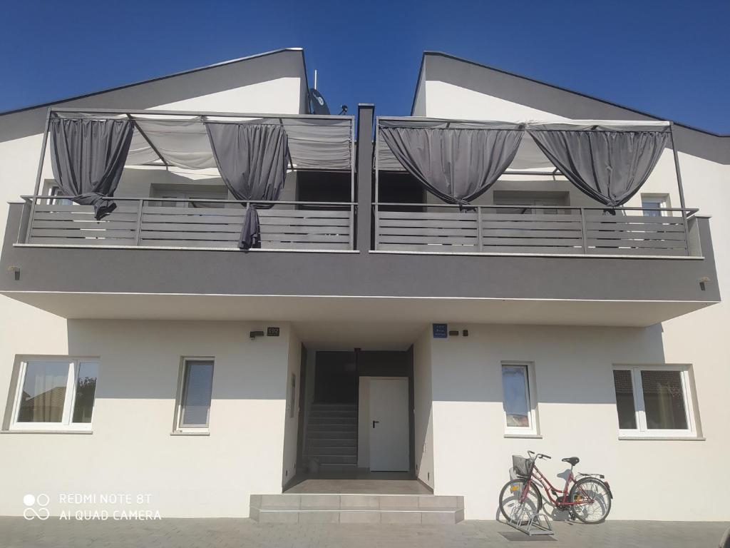 een gebouw met een balkon met twee fietsen erop geparkeerd bij Apartments LAURA in Fažana