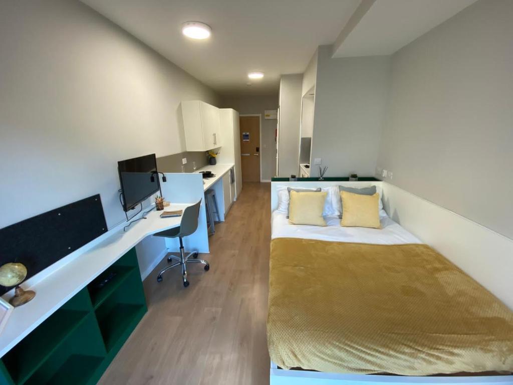 a bedroom with a bed and a desk with a computer at The Depot in Bath in Bath