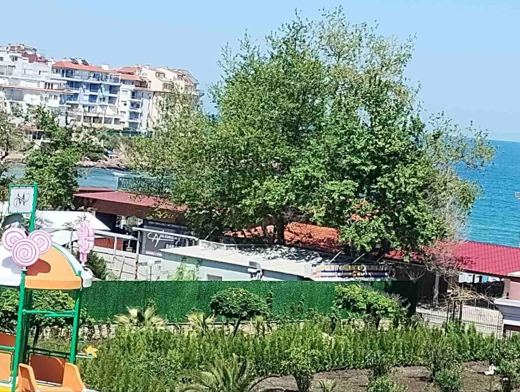 a view of a garden with the ocean in the background at Sozopol Harmani Beach Apartment 10 in Sozopol