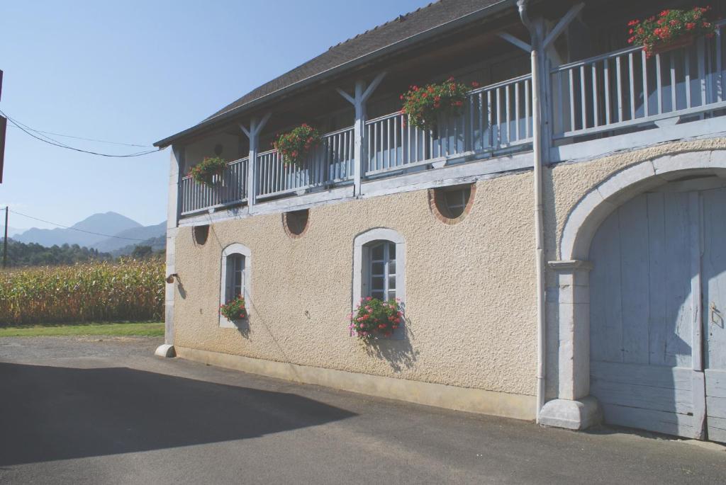 un bâtiment avec des boîtes de fleurs sur son côté dans l'établissement Maison Palu, à Asson