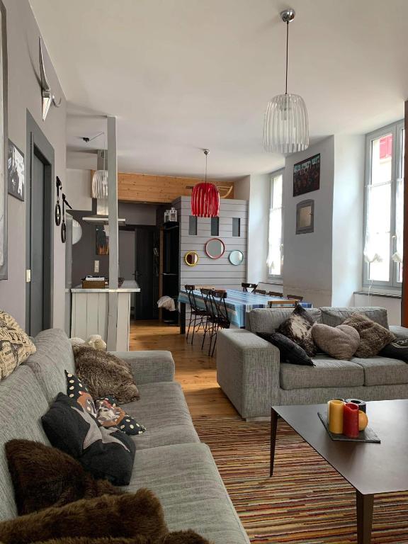 un salon avec deux canapés et une cuisine dans l'établissement Grand appartement 2 à 8 personnes, à Cauterets