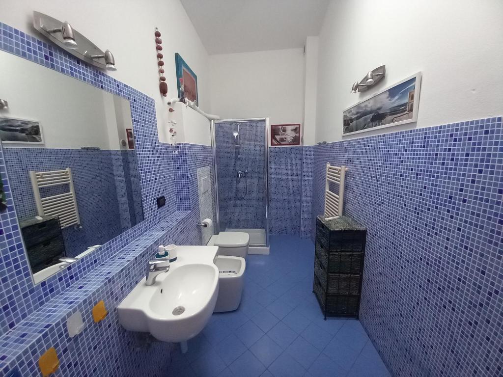 W wyłożonej niebieskimi kafelkami łazience znajdują się 2 toalety i umywalka. w obiekcie "La Casita", 2 Floors Apartment, Private Parking 1 car OR 2 Bikes, Air-Cond and Terrace w mieście Livorno