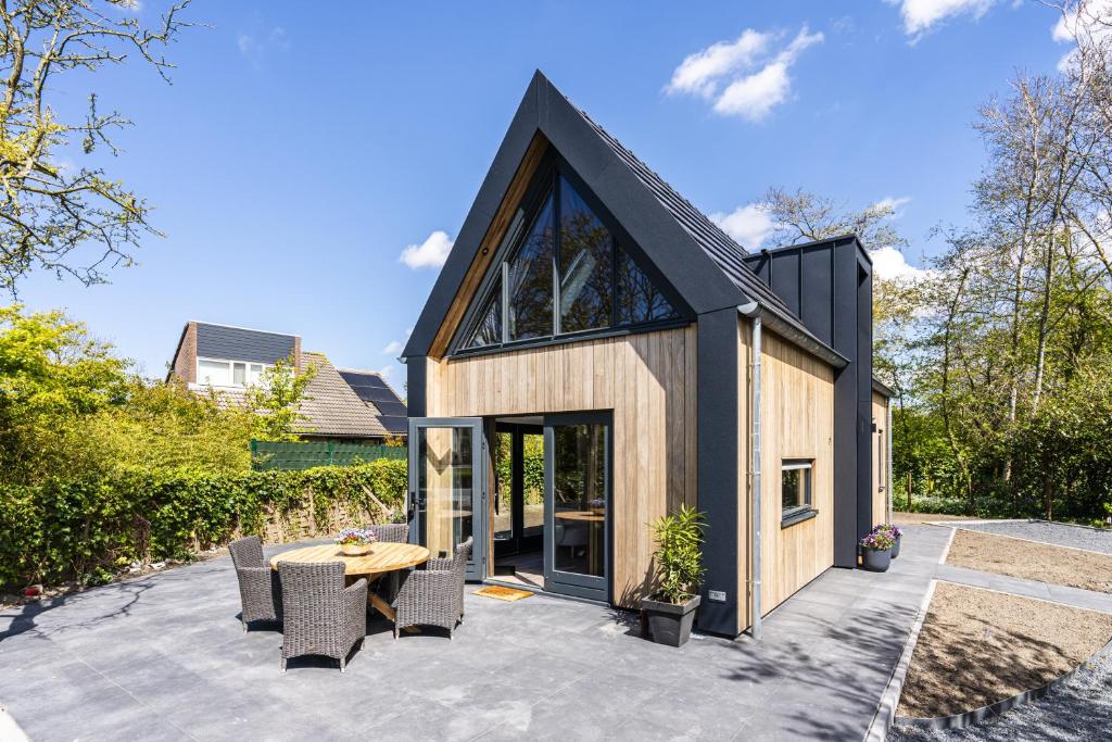a house with a black roof and a patio at Nieuw vakantiehuis Domburg, in centrum dichtbij strand in Domburg
