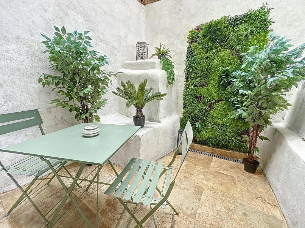a green table and chairs on a patio with plants at Le Petit Patio in Aix-en-Provence