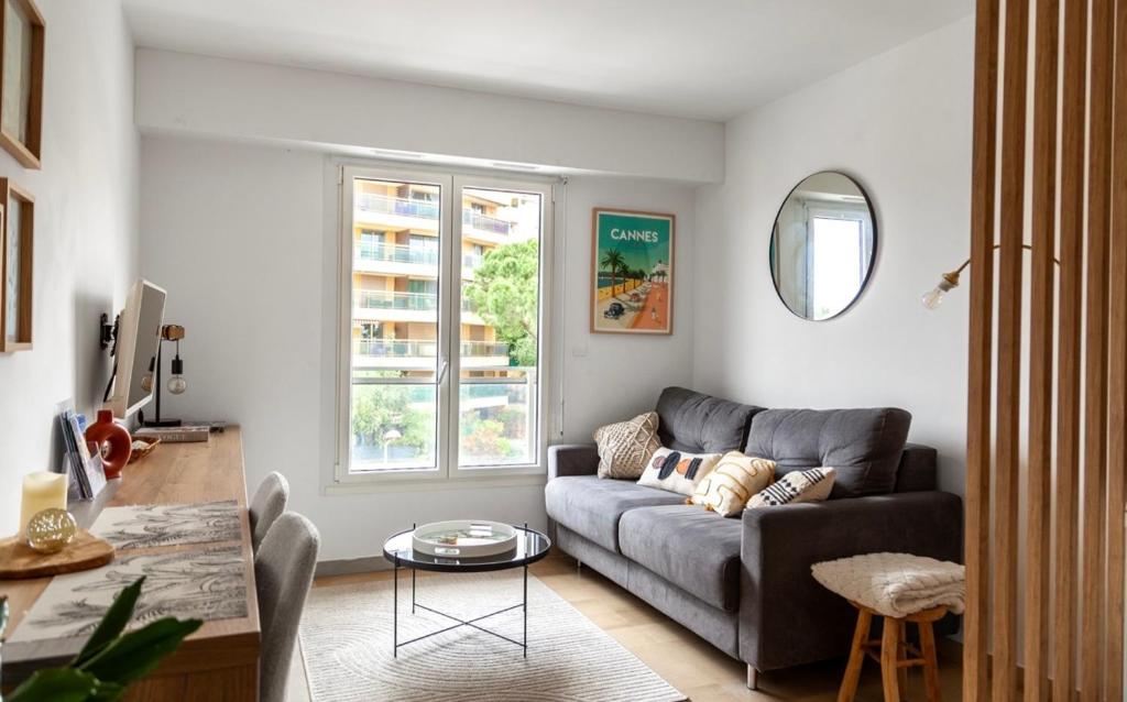 a living room with a couch and a table at Studio lumineux à 2 mn à pied de la plage in Cannes