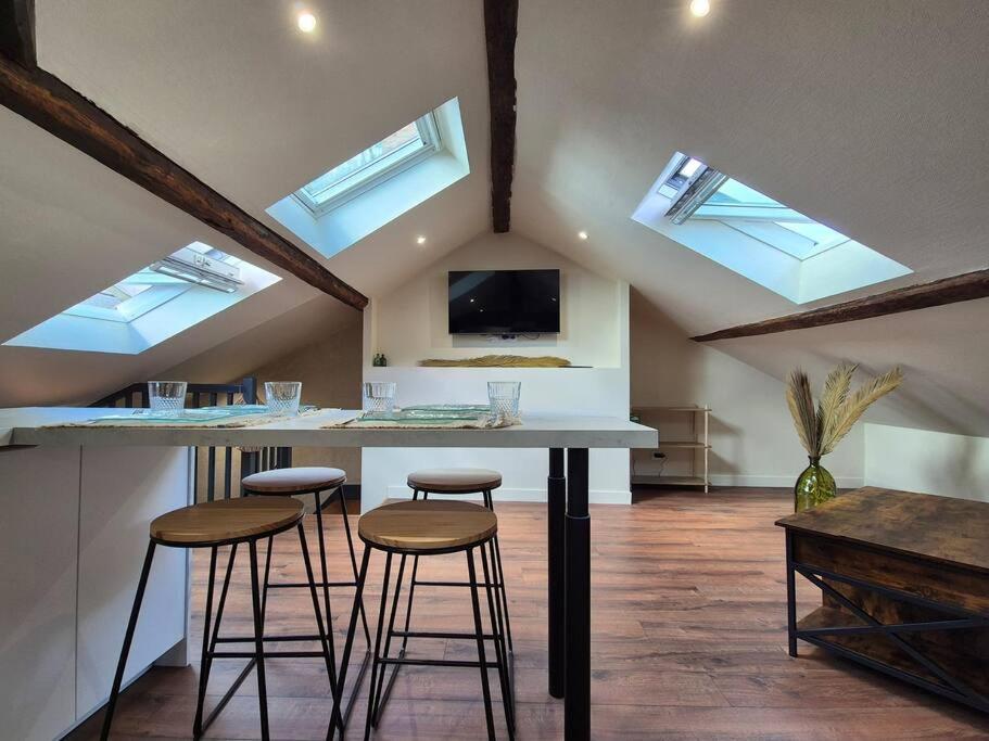 une cuisine avec un comptoir et des tabourets dans une pièce dans l'établissement Le Saint-Aubin, à Angers