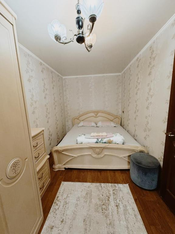 Habitación pequeña con cama y lámpara de araña. en Квартиры рядом с Аэропортом города Алматы en Turksib