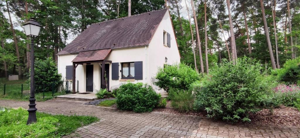 ein kleines weißes Haus mit schwarzem Dach in der Unterkunft Maison d'une chambre avec jardin et wifi a Arbonne la Foret in Corne-Biche