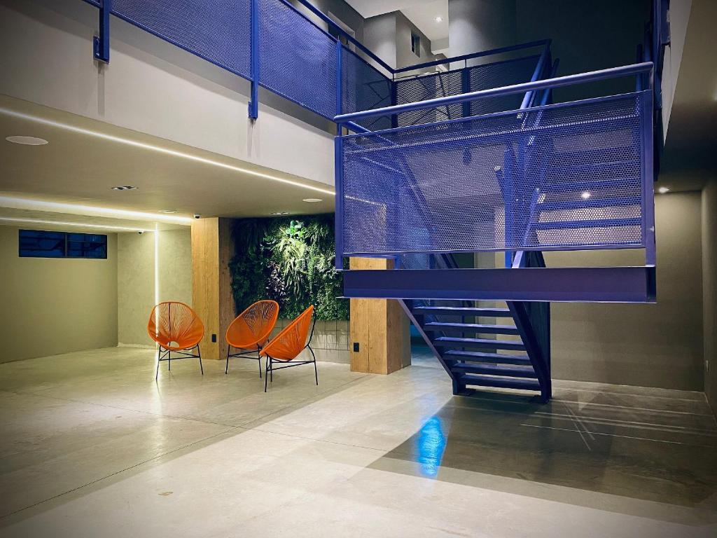 una escalera en una habitación con 2 sillas naranjas en Sun Smart Hotel en Recife