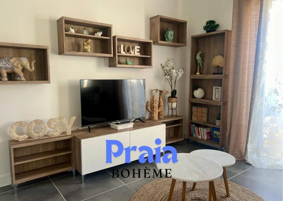 un salon avec une télévision à écran plat sur un centre de divertissement dans l'établissement Praia Bohème, à Mauguio