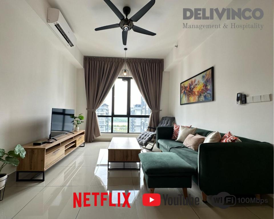 sala de estar con sofá verde y TV en Kamalinda Haven: 3BR/2BA - Steps Away for 5pax, en Shah Alam
