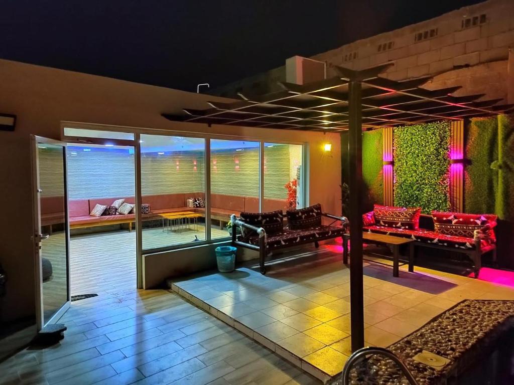 una sala de estar con sofás rojos y una mesa. en شاليهات الرويلي, en Al Fayşalīyah