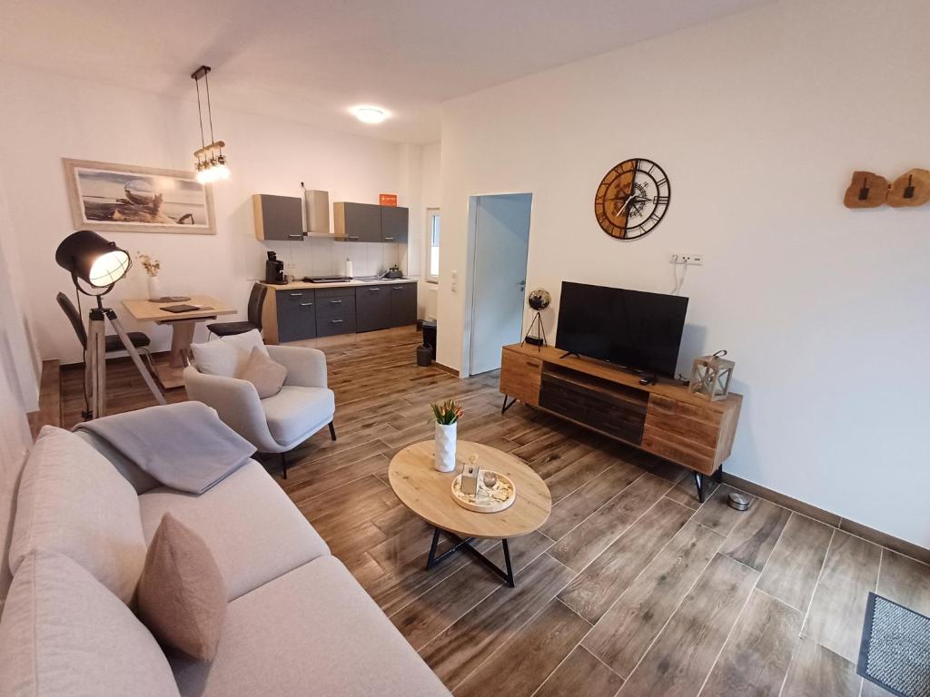 a living room with a couch and a tv and a table at Ferienapartment Zur Bunten Kuh Walporzheim in Bad Neuenahr-Ahrweiler