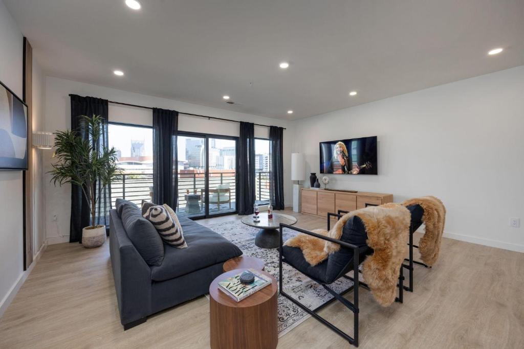 a living room with a couch and a table at Hyve - Eden Elegance - Walk to Broadway in Nashville