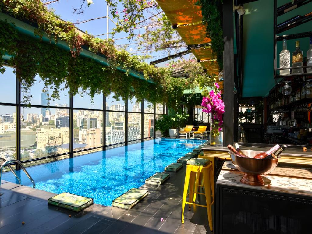 uma piscina com um bar com vista para a cidade em The Smallville Hotel em Beirute