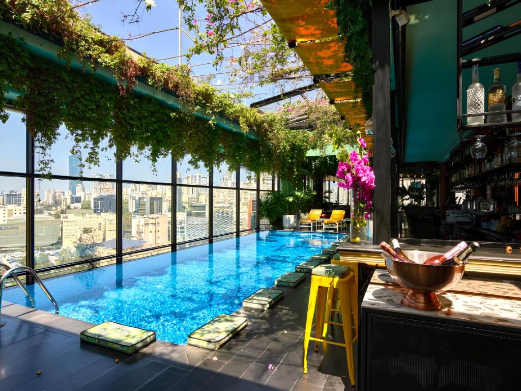 a pool with a bar with a view of the city at The Smallville Hotel in Beirut