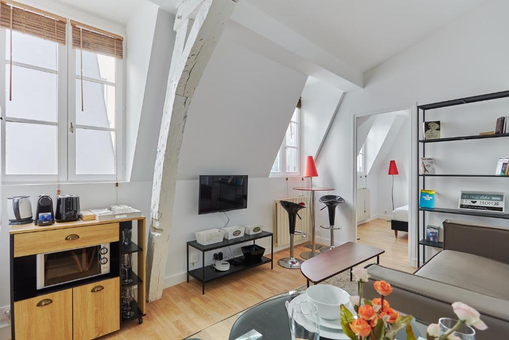 ein Wohnzimmer mit einem Sofa und einem TV in der Unterkunft Charming 1 bedroom flat Coeur du Marais By Studio Prestige in Paris