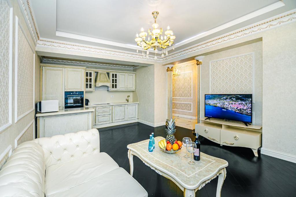 ein Wohnzimmer mit einem weißen Sofa und einem Tisch in der Unterkunft Park Azure Deluxe Apartment By Baku Housing in Baku