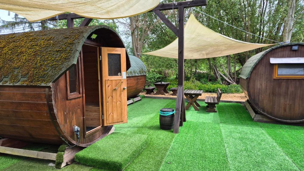 einen Hof mit einem kleinen Haus auf Gras in der Unterkunft Mini Hotel Übernachten Im Gurkenfass in Lübbenau