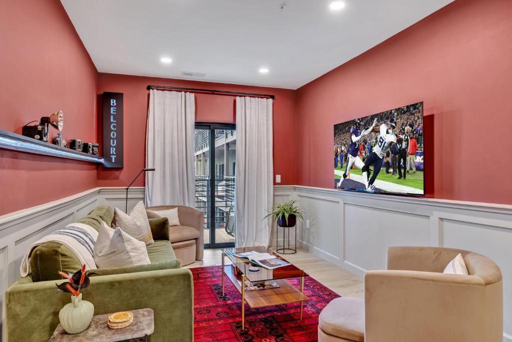 納許維爾的住宿－Nashville - 635 7th Ave S Unit 412，客厅设有红色的墙壁和电视。