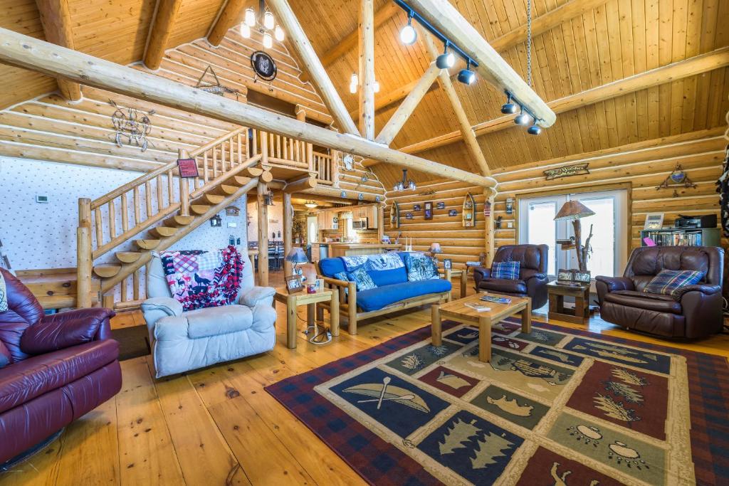 uma sala de estar com paredes de madeira e um tecto de madeira em Log cabin- Lake- kayaks- close to South Haven em Paw Paw