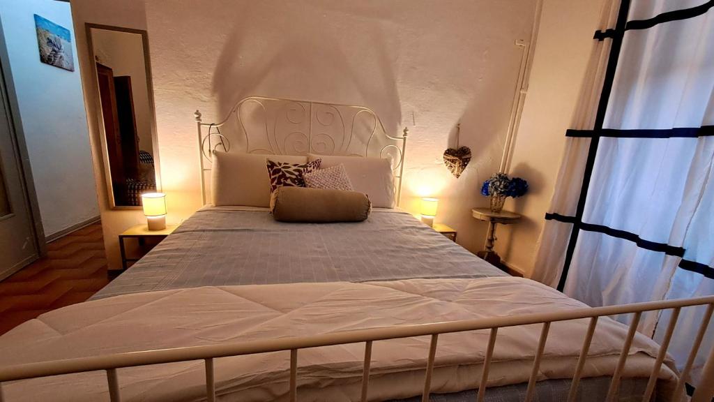 ein Schlafzimmer mit einem großen weißen Bett mit zwei Lampen in der Unterkunft Blue Breeze Apartment in Germignaga