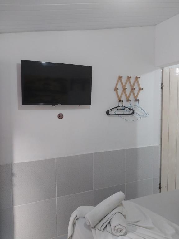 a bathroom with a flat screen tv on the wall at Pousada Porto Marola in Porto De Galinhas