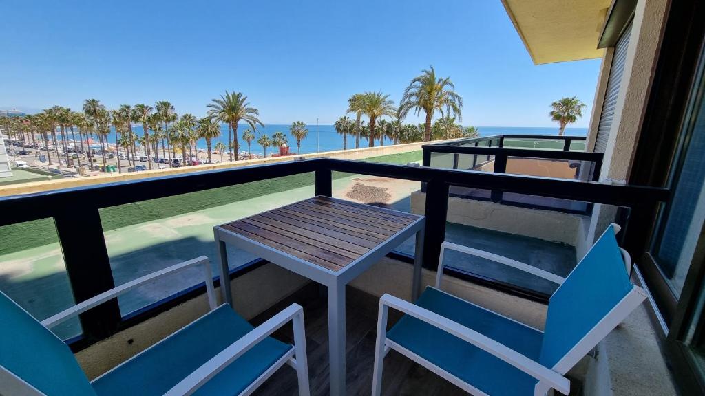 a table and chairs on a balcony with a view of the beach at Blue Aloha Sea View in Benalmádena