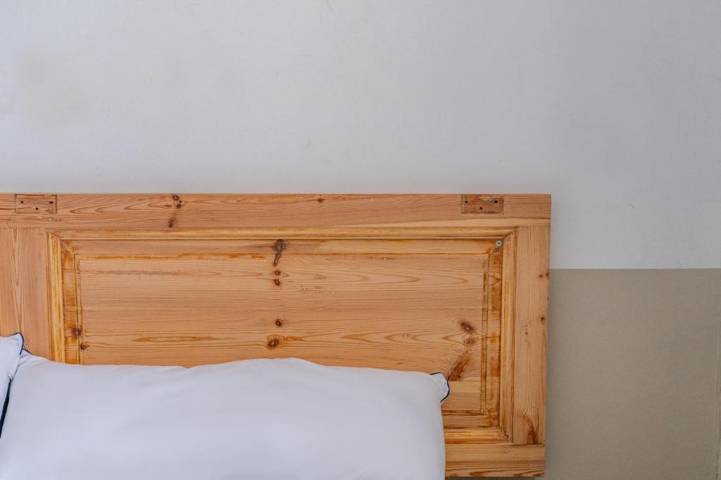 łóżko z drewnianym zagłówkiem w pokoju w obiekcie Verdi 254 w Barcelonie