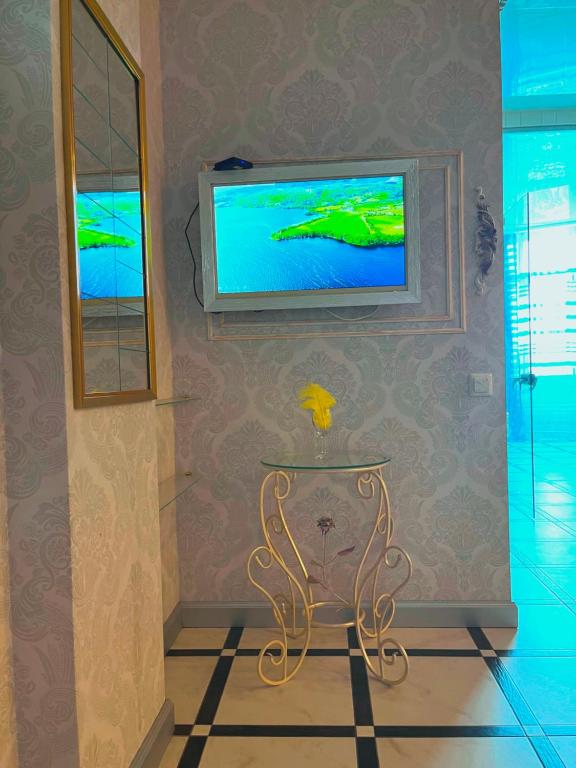 オデッサにあるПЛЯЖ Otrada Две Спальни на Французском бульваре, centre, Delux Большой апартаментのテレビ、ガラスのテーブルが備わる客室です。