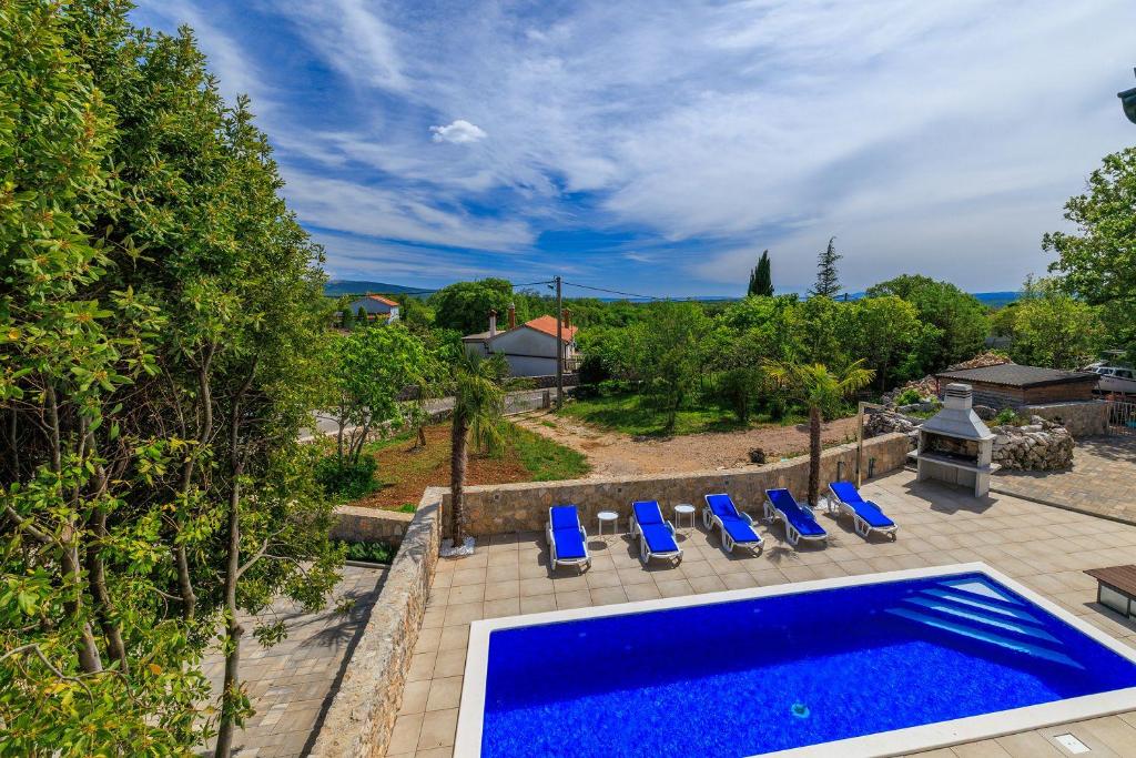 uma piscina exterior com espreguiçadeiras azuis e uma piscina em Mit Pool, Balkon unweit von Heilschlamm Bucht em Kras