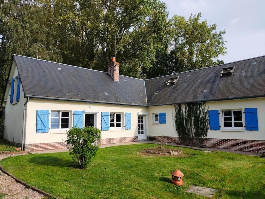 a white house with blue windows and a yard at Longère 10 personnes in Vauchelles-lès-Quesnoy