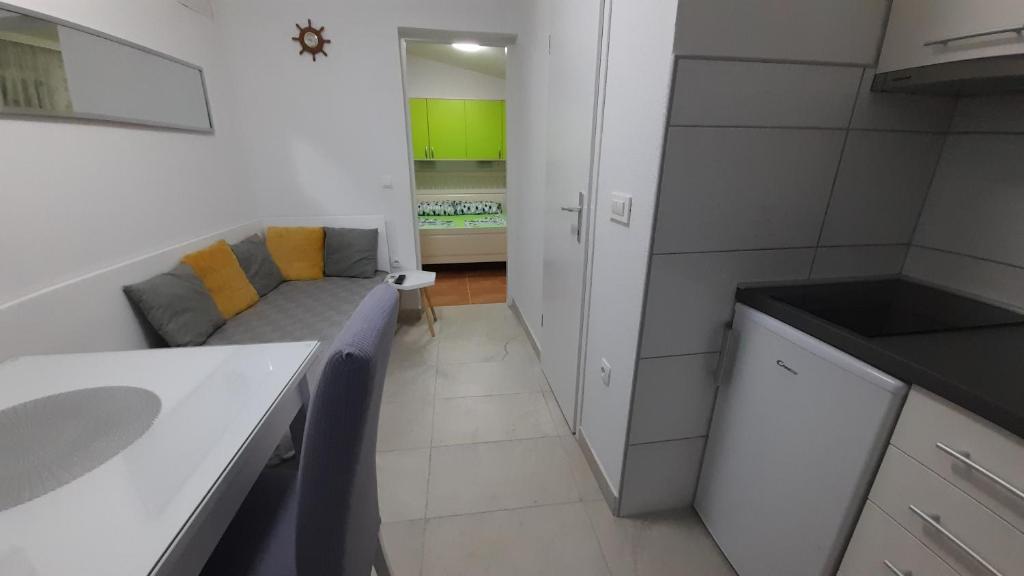 um pequeno quarto com um sofá e uma cozinha em Apartment HORVAT 2 em Vir