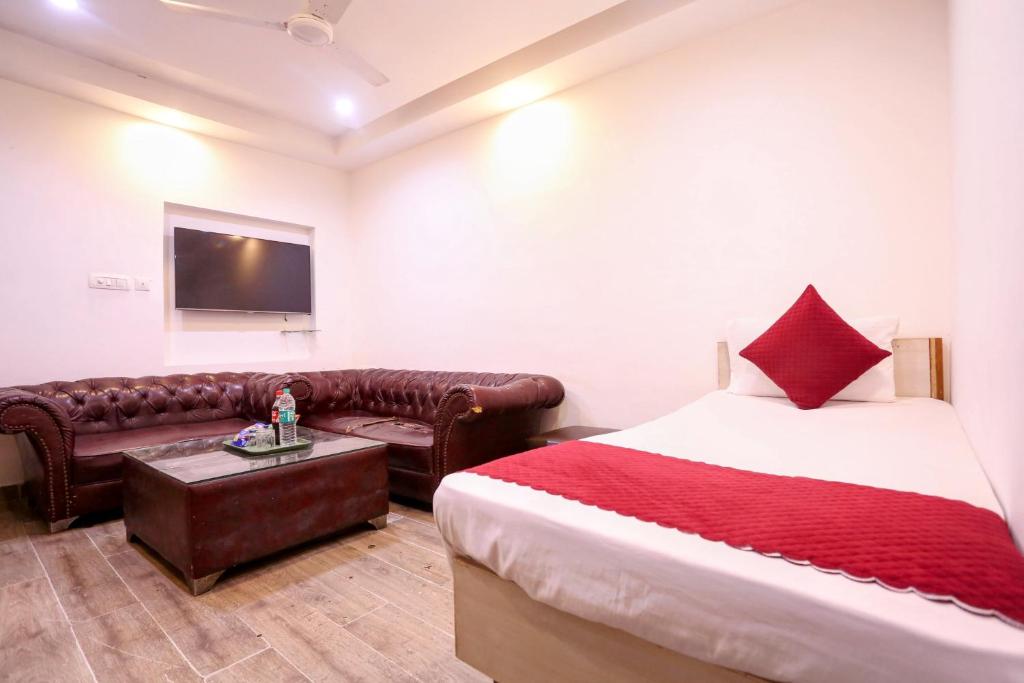 um quarto de hotel com uma cama e um sofá em Hotel Shillo Nizamuddin em Nova Deli