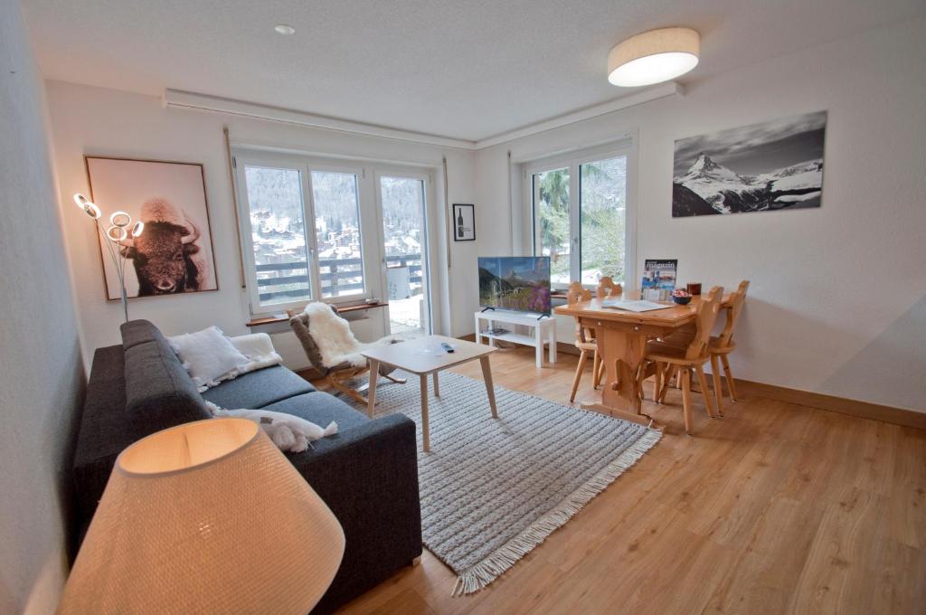 a living room with a couch and a table at Haus Bodmen C, Apartment Grünsee in Zermatt